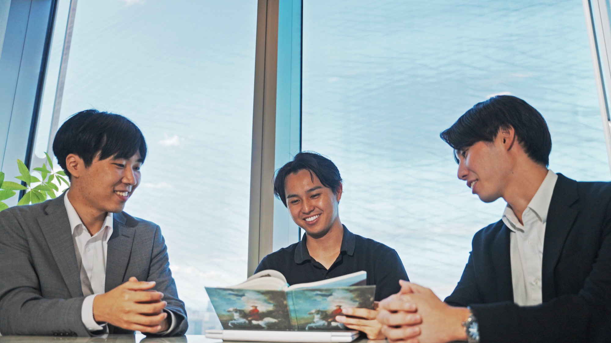 窓辺で資料を見ながら語り合う社員